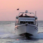 Yacht in Fahrt auf uns zu bei rosa Sonnenuntergang