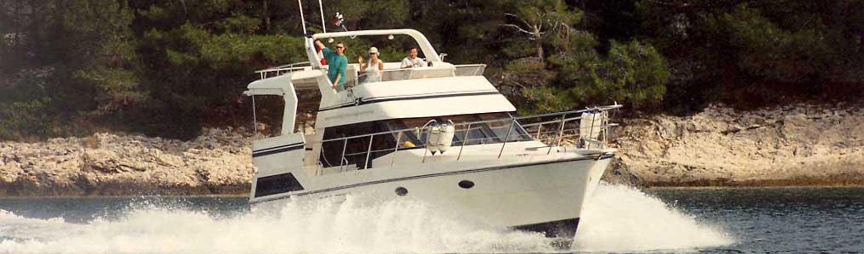 Yacht in Fahrt mit winkenden Personen